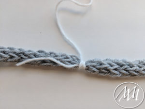 Wrapping yarn around necklace 