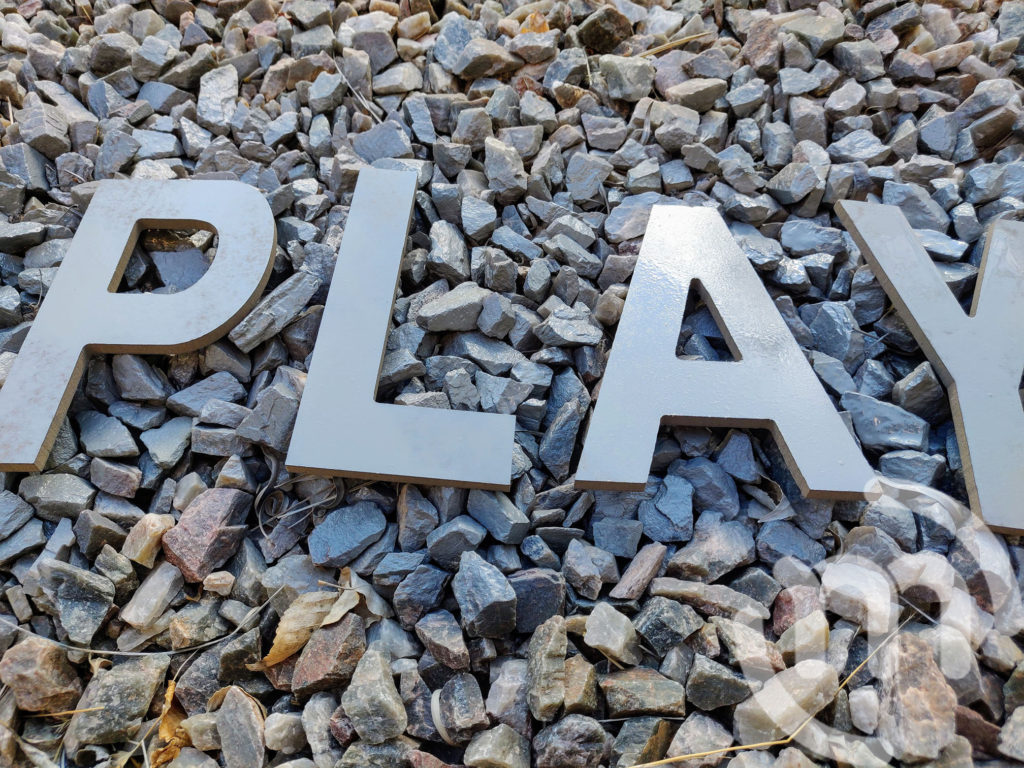 The word "play" Spray Painted in Rocks